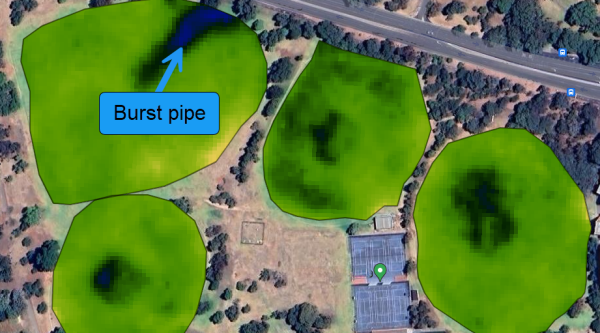 Satellite vegetation imagery of multiple sports fields showing a dark, over-irrigated area caused by a burst irrigation pipe.