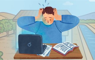Stressed irrigation manager sitting at a desk with a laptop and paperwork, holding his head, with orchard rows and an irrigation channel in the background